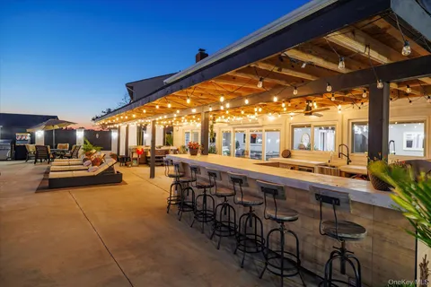 a dining hall with stainless steel appliances lots of white furniture a table and chairs