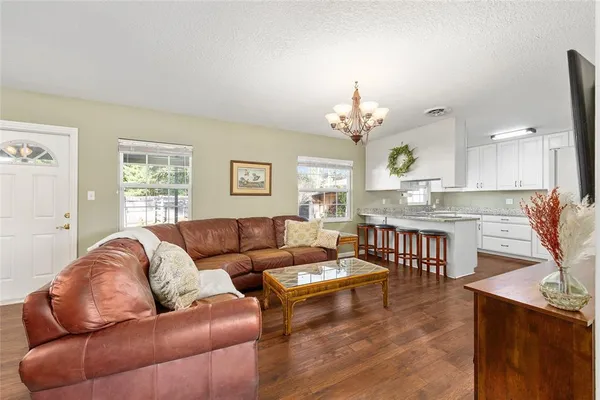 a living room with furniture a chandelier and a dining room