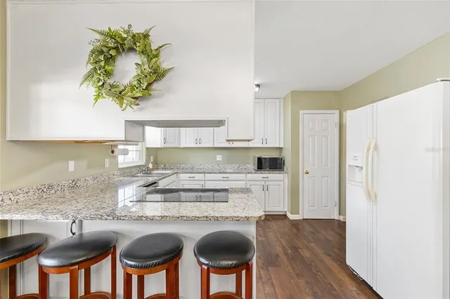 a kitchen with stainless steel appliances granite countertop a stove a sink and a refrigerator