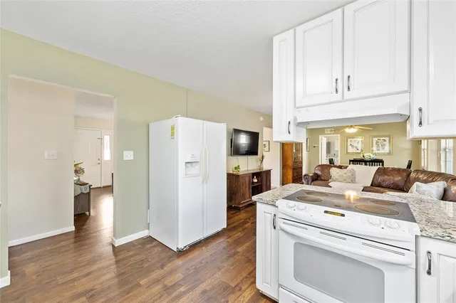 a living room with furniture and a refrigerator