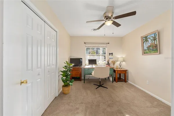 a view of a workspace with furniture and a window
