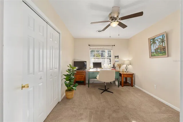 a view of a workspace with furniture and a window