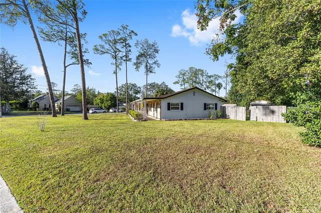 a view of a house with backyard and tree s