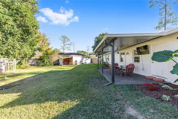 a view of a house with backyard porch and sitting area