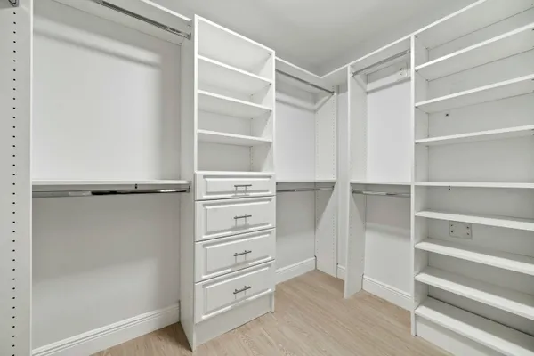 a view of walk in closet with empty racks