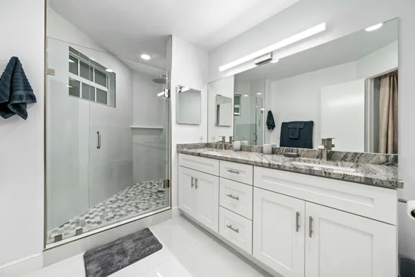 a bathroom with double sink and a mirror
