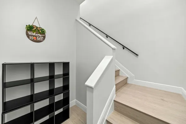 a view of a hallway with wooden floor and staircase