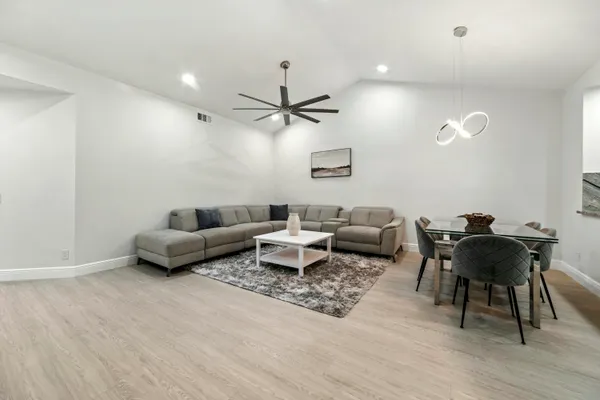 a living room with furniture and a ceiling fan