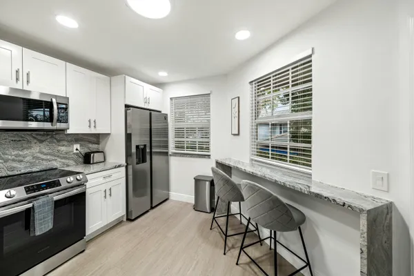 a kitchen with stainless steel appliances a stove a sink refrigerator and microwave