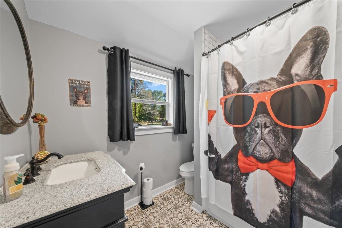9301 Osborn Road Arlington, TN 38002 - Photo 18 of 31 a bathroom with a granite countertop toilet sink and mirror