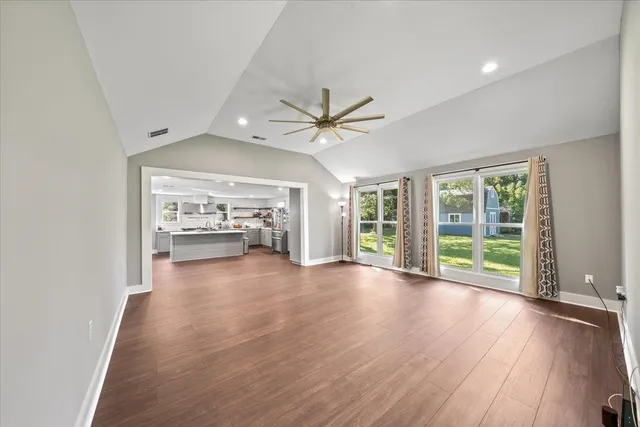 a view of n empty room with window and wooden floor
