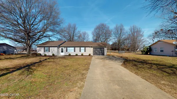 a front view of a house with a yard and trees