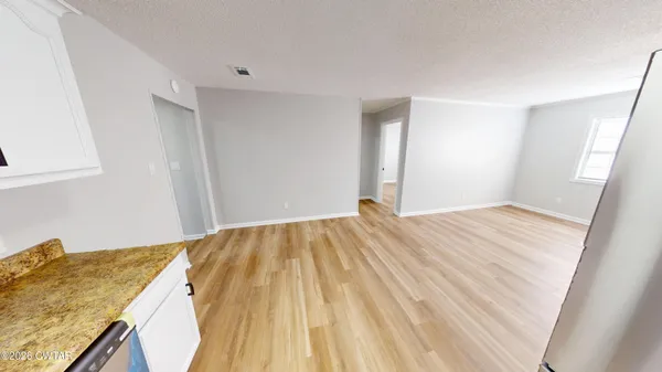 a view of a bedroom with wooden floor and bathroom