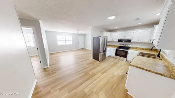 a kitchen with stainless steel appliances granite countertop a refrigerator stove microwave and sink