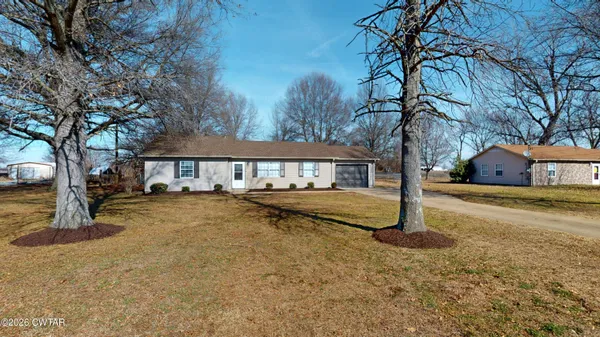 a view of a house with large trees and a big yard