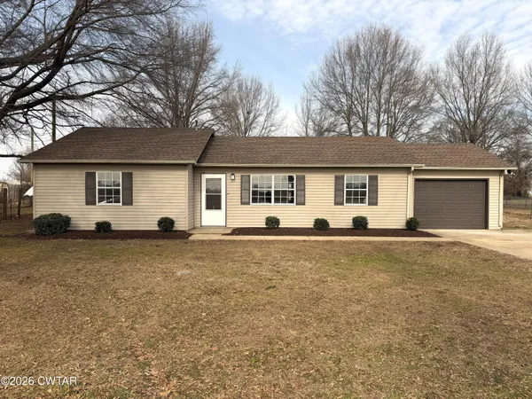 a front view of house with yard and trees