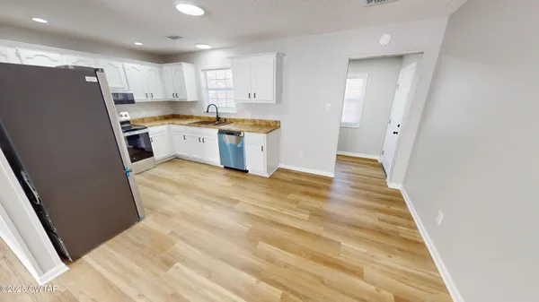 a kitchen with white cabinets and stainless steel appliances