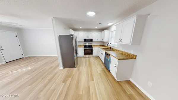a large kitchen with a lot of counter space and wooden floor