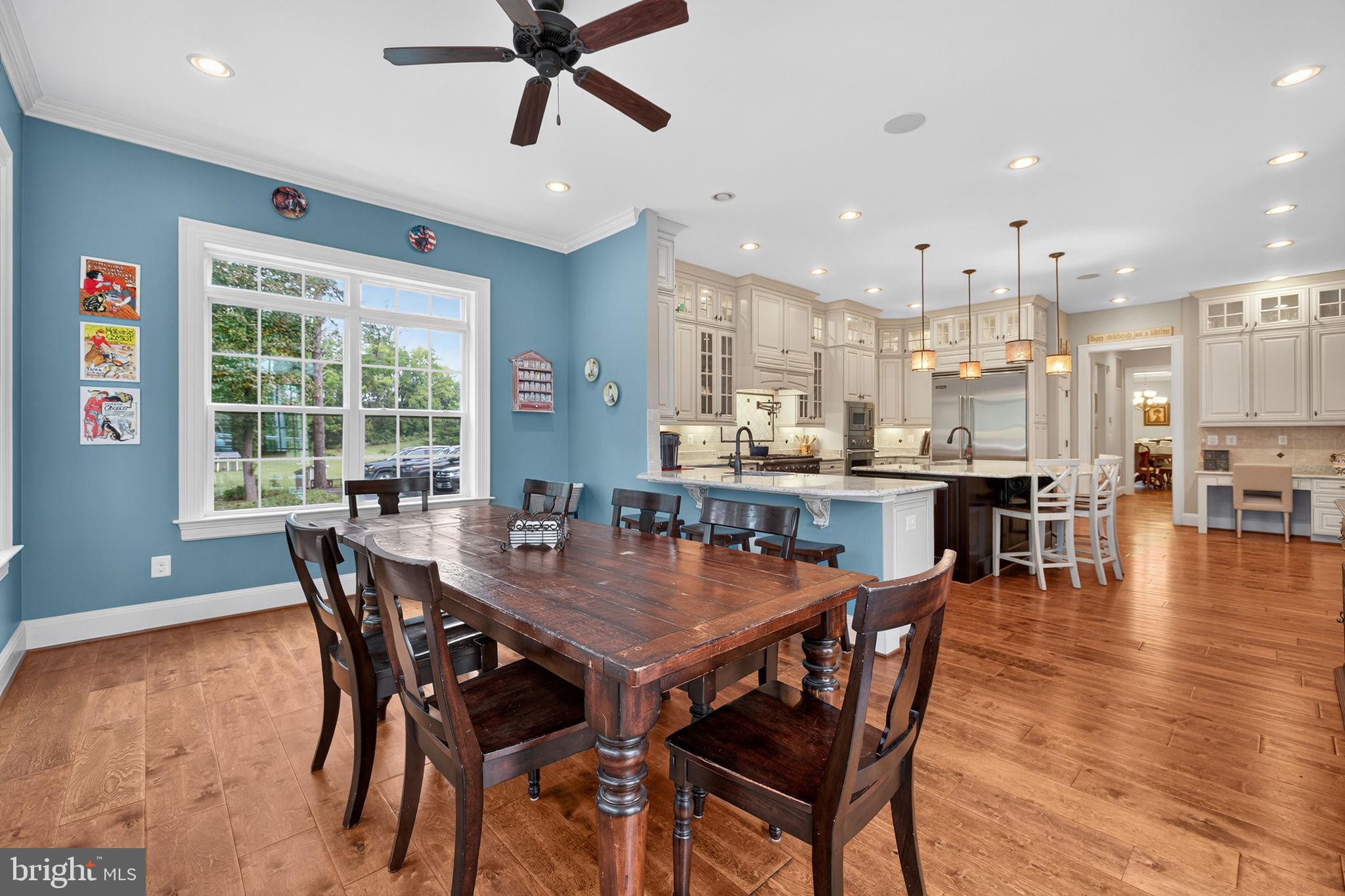 22011 Beaverdam Drive Ashburn, VA 20148 - Photo 39 of 106 a view of a dining room and livingroom with furniture wooden floor a rug a fireplace and a kitchen view