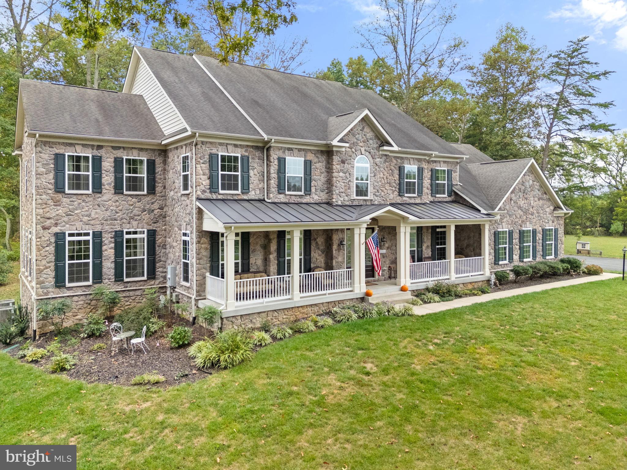 22011 Beaverdam Drive Ashburn, VA 20148 - Photo 5 of 109 Elegant stone home with lush green surroundings.