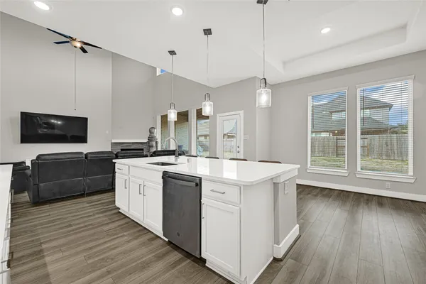 a kitchen with stainless steel appliances kitchen island granite countertop a stove a sink a refrigerator and a dining table with wooden floor