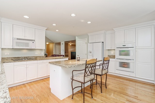 20 Lochbrook Lane Inverness, IL 60010 - Photo 5 of 27 a kitchen with stainless steel appliances kitchen island granite countertop a stove a sink a refrigerator and white cabinets with wooden floor