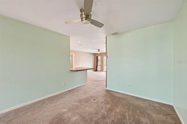 a view of a room with a ceiling fan and wooden floor