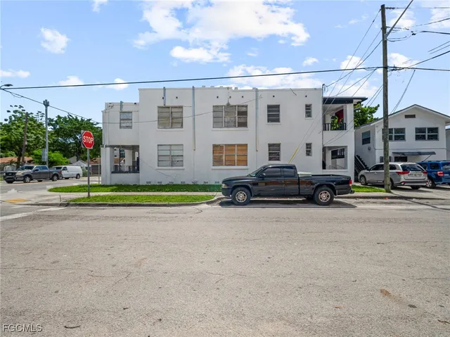 a view of building with cars parked across