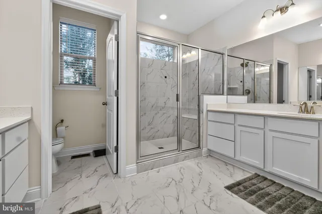 a spacious bathroom with a shower sink and mirror