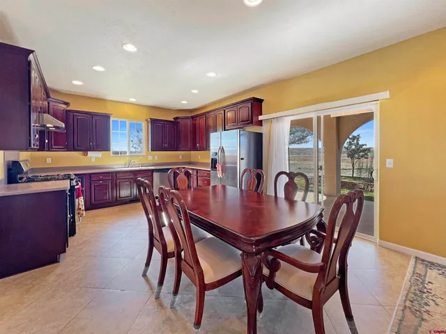 a view of a dining room and livingroom with furniture a rug a kitchen and a chandelier