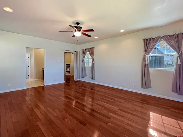 a view of an empty room with a window and wooden floor