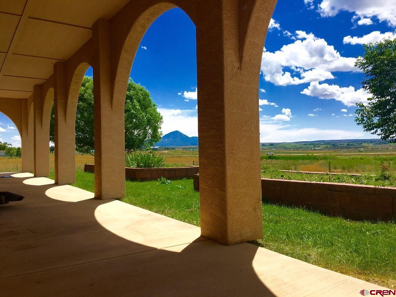 13723 Road 23 Cortez, CO 81321 - Photo 25 of 45 a view of a swimming pool with lawn chairs and a big yard