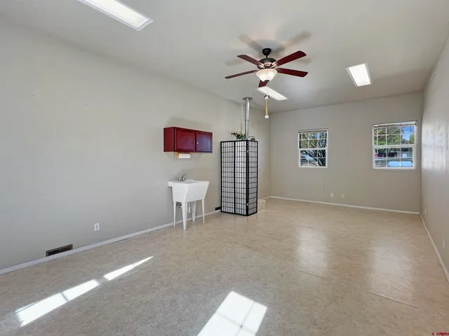 a view of a livingroom with a ceiling fan and window
