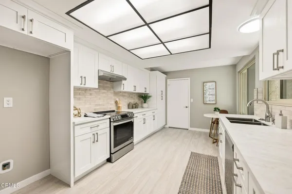 a kitchen with white cabinets and white appliances