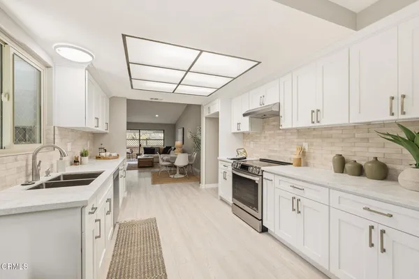 a kitchen with white cabinets and appliances