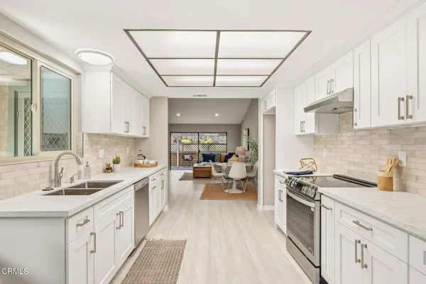 a kitchen with stainless steel appliances a sink stove and cabinets