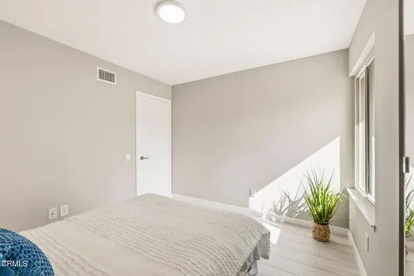 a bedroom with a bed and a potted plant