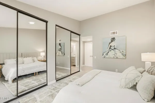 a bedroom with a large bed and a glass door shower