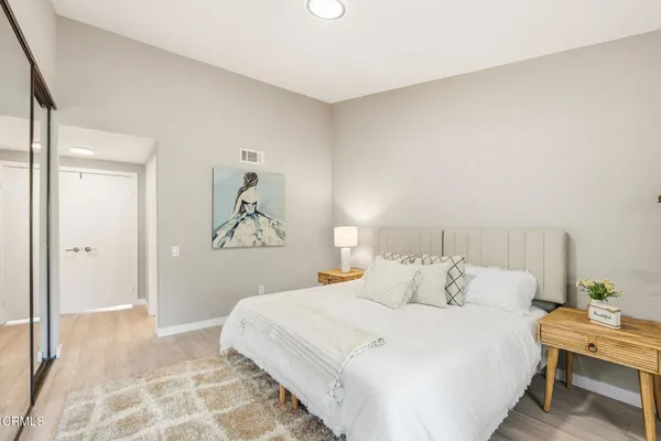 a bedroom with a bed and a painting on the wall