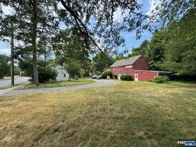 a front view of a house with a yard and tree s