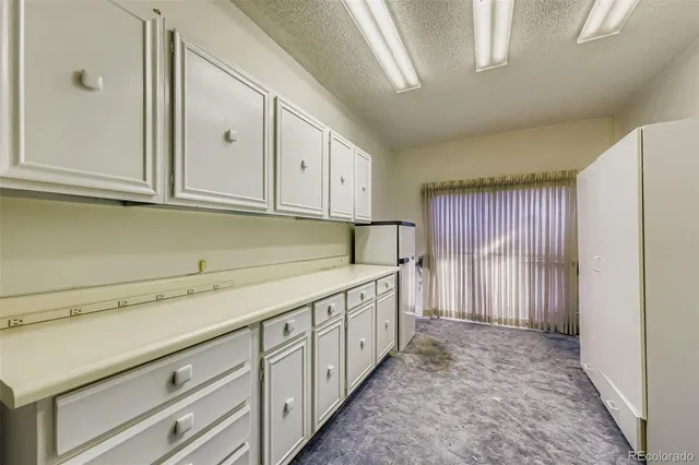 a kitchen with granite countertop white cabinets and stainless steel appliances