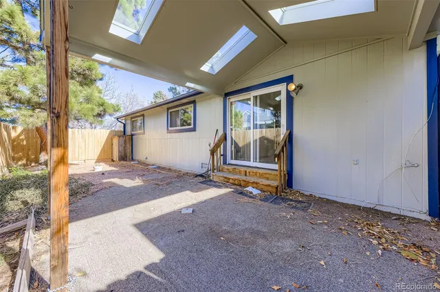 a backyard of a house with barbeque oven table and chairs