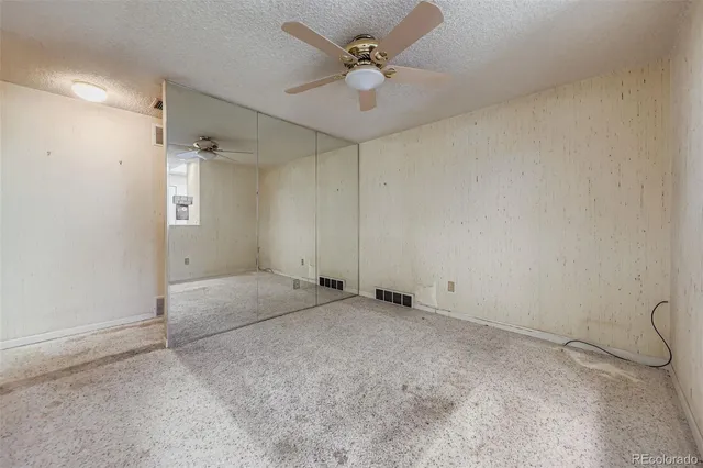 an empty room with a ceiling fan and a window