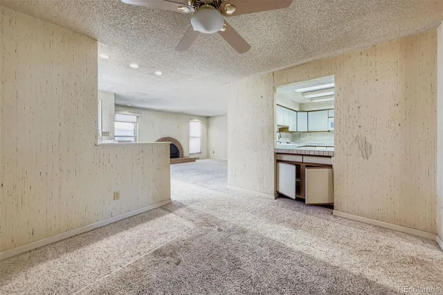 an empty room with windows and fan