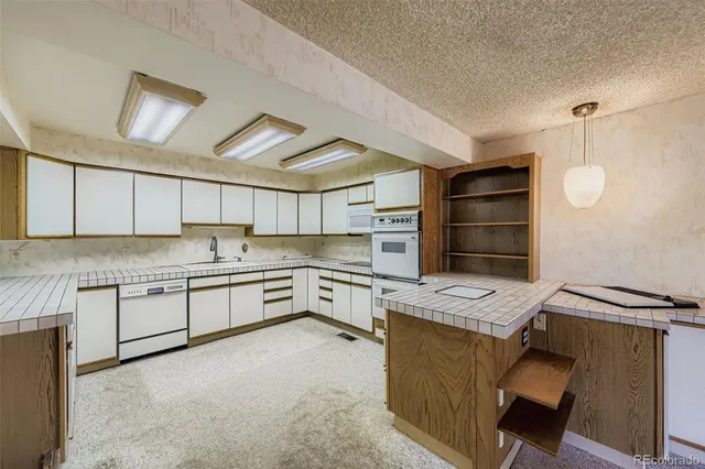a kitchen with granite countertop a sink cabinets stainless steel appliances and a window