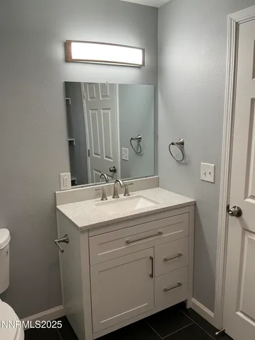 a bathroom with a sink a toilet and mirror
