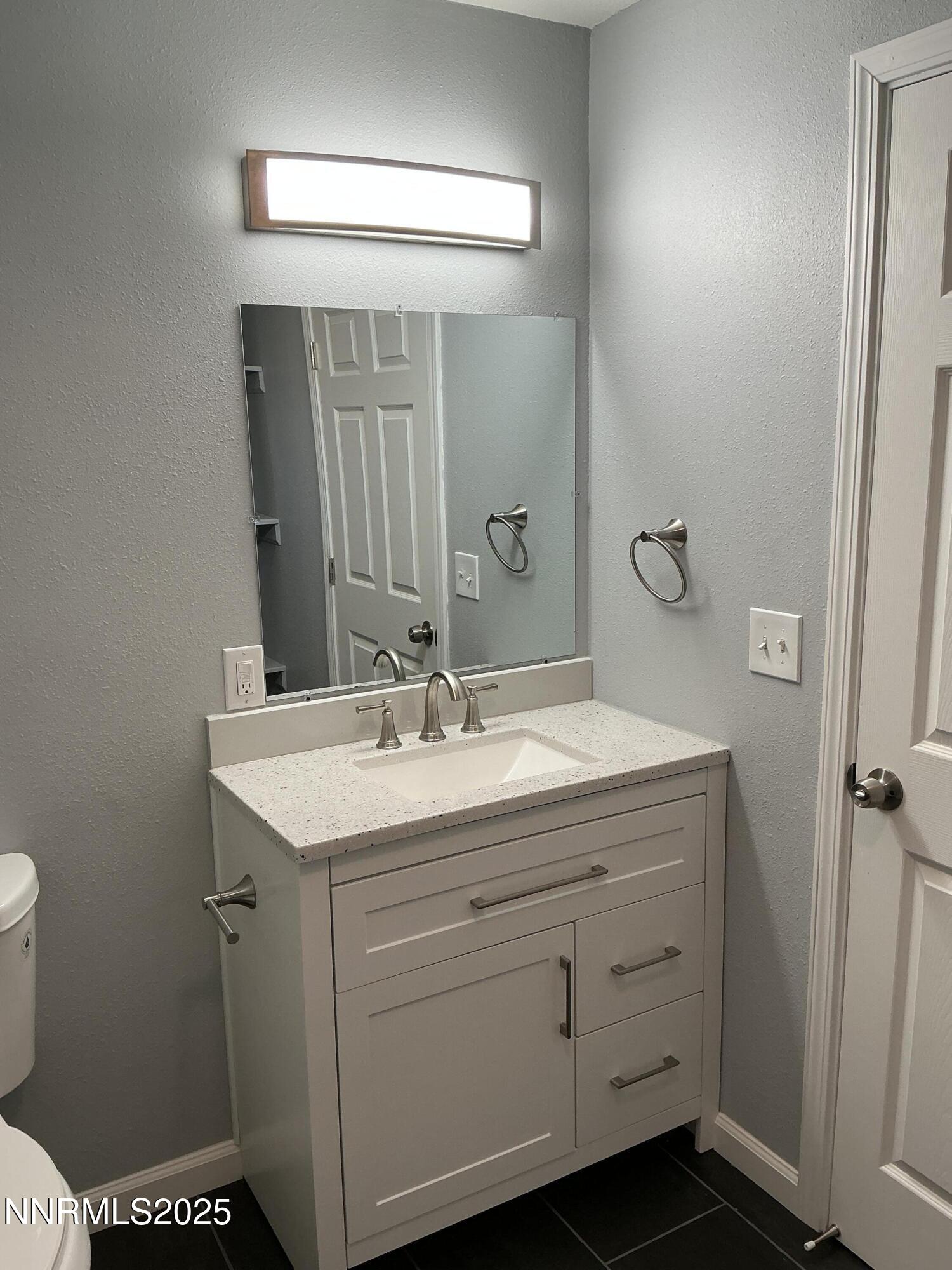 905 Mauldin Lane Reno, NV 89502 - Photo 11 of 21 a bathroom with a sink a toilet and mirror