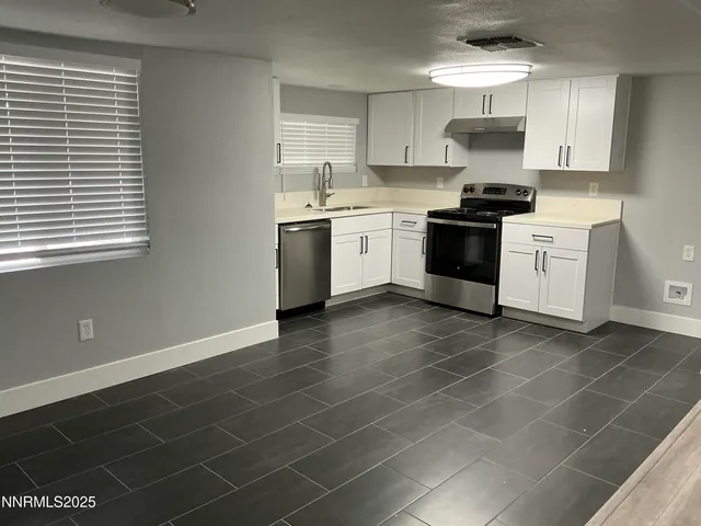 a kitchen with a sink a stove and cabinets