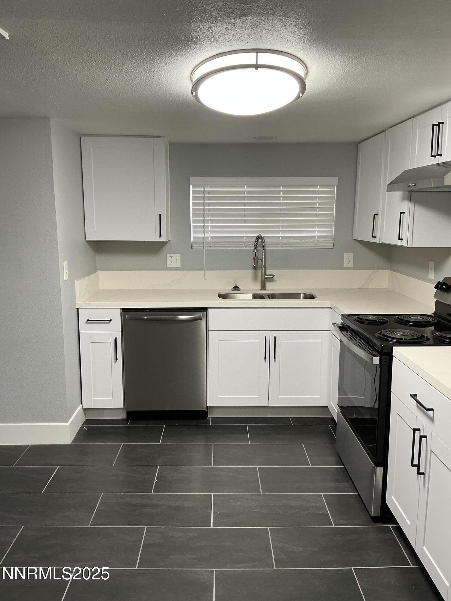 905 Mauldin Lane Reno, NV 89502 - Photo 3 of 21 a kitchen with a sink a stove a microwave and cabinets