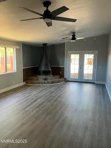 a view of a livingroom with wooden floor and a ceiling fan